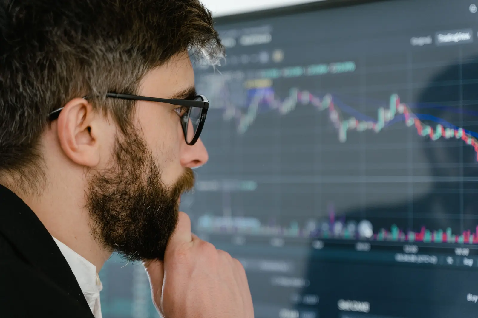 Investor studying a stock market chart on a screen (stock photo)